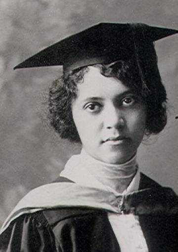 Alice Ball wearing an academic gown and hat, staring slightly off camera.