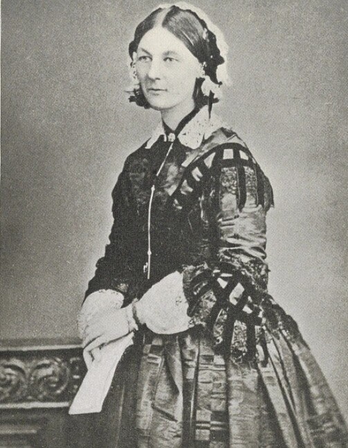 Florence Nightingale is holding what looks like a letter and staring off-camera.