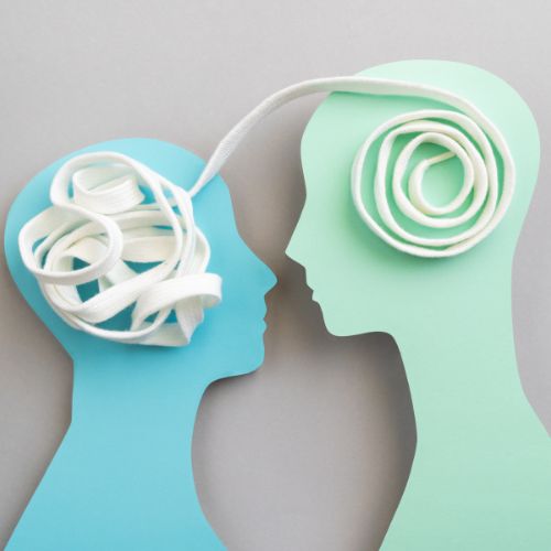 Two figures face each other, one is blue and the other green. A ribbon connects each of them through the head. One ribbon is neatly wrapped, while the other is bunched together.