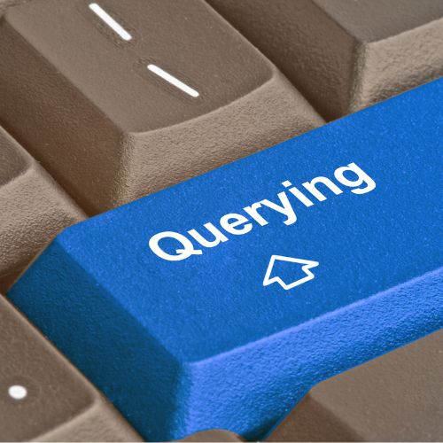 Blue querying key on keyboard in white letters with an arrow pointing up, surrounded by brown keys.