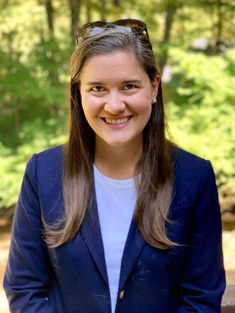Picture of Kaitlyn Davis, long brown hair wearing a blue blazer and white t-shirt.