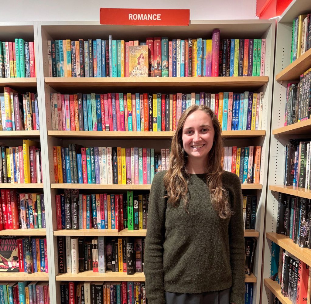 Kerryann standing in front of a bookcase in a bookstore.