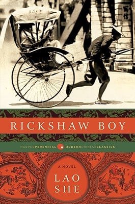 The cover of the classic satirical novel Rickshaw Boy by Lao She. On the cover is an image in black and white of a young man in dark clothing, bent over as he pulls the rickshaw --- a covered wagon.