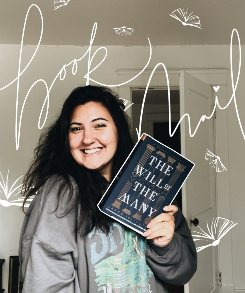 Image of Kenzie G. smiling and holding up a copy of the book The Will of the Many in front of an open door. Overlaid atop the photo are the words "book mail" in white cursive along with line drawings of books floating open.