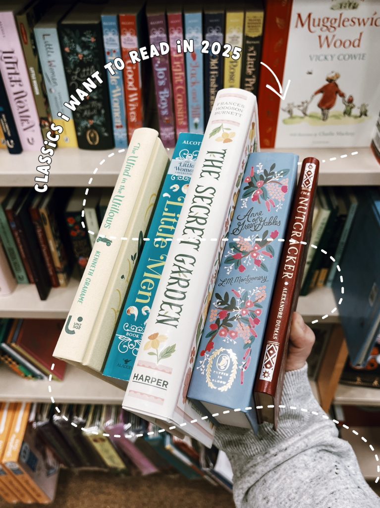 Kenzie G's arm holding up five books in front of a bookshelf. The books are, from left to right: The Wind in the Willows by Kenneth Grahame, Little Men by Louisa May Alcott, The Secret Garden by Frances Hodgson Burnett, Anne of Green Gables by Lucy Maud Montgomery, and The Nutcracker by Alexandre Dumas. A white dashed trail swirls around the books. Curved around the top of the books is text reading "Classics I want to read in 2025," accompanied by a white arrow pointing to the books.