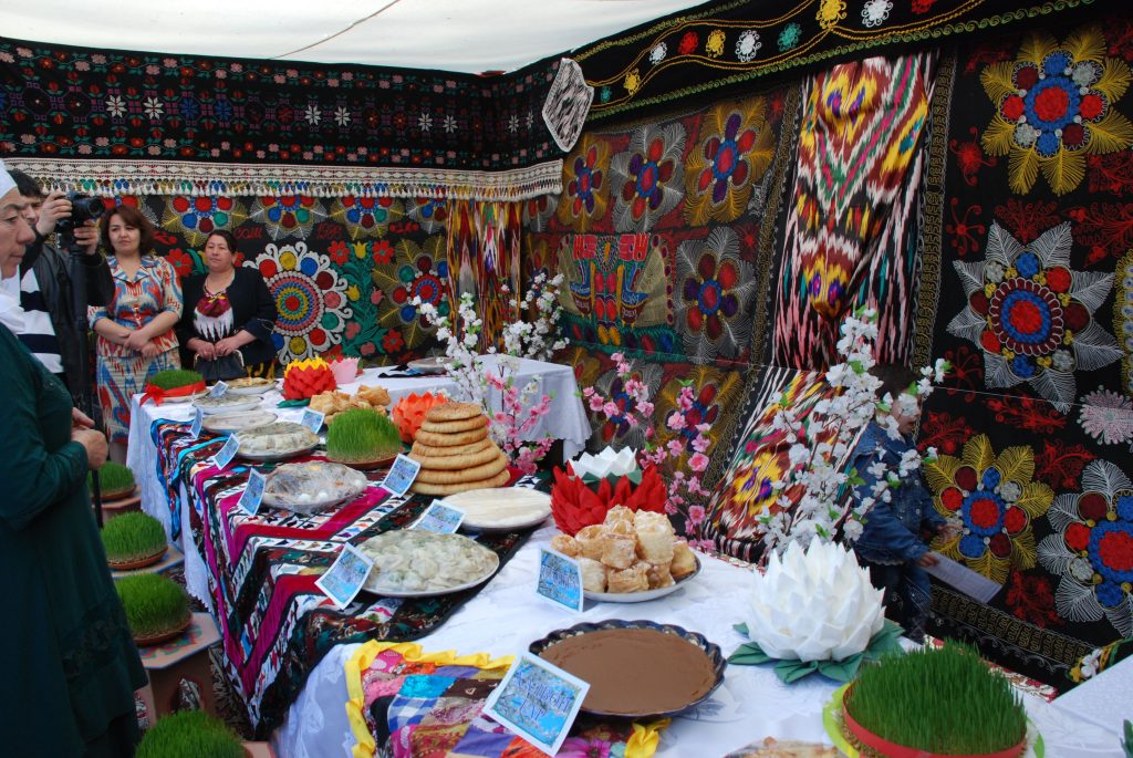 Nowruz Celebration in Tajikistan features a festive table with traditional dishes, vibrant embroidery, and sabzeh, marking the Persian New Year.