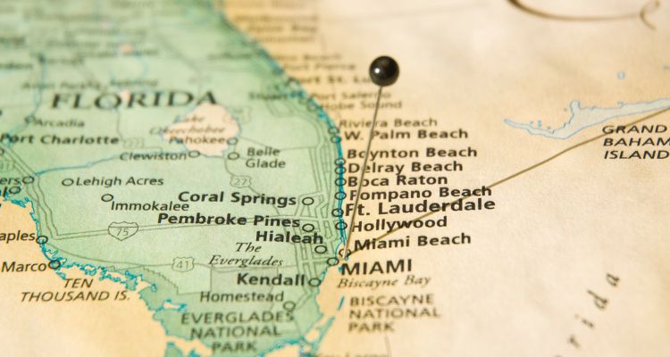 An image of the map of Southern Florida with a number of cities listed. A pin with a black tip is placed on Miami.