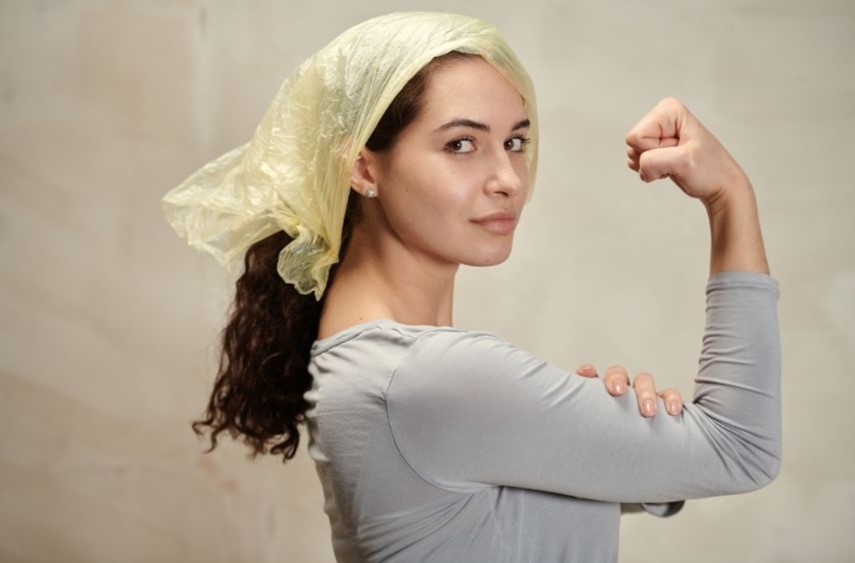 A woman flexing one arm with her hand on her bicep.