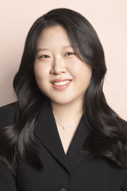 Portrait of Axie Oh. She is wearing a black blazer and has dark black hair, smiling at the camera.