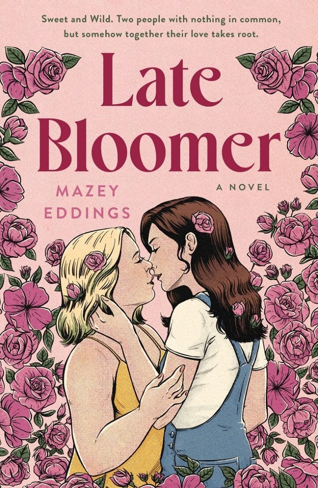 A pink background covered in dark pink roses. Two women with roses in their hair hold each other and are about to kiss. The woman on the left wears a yellow tank top. The woman on the right wears a white t-shirt and blue overalls. Late Bloomer in dark pink lettering.