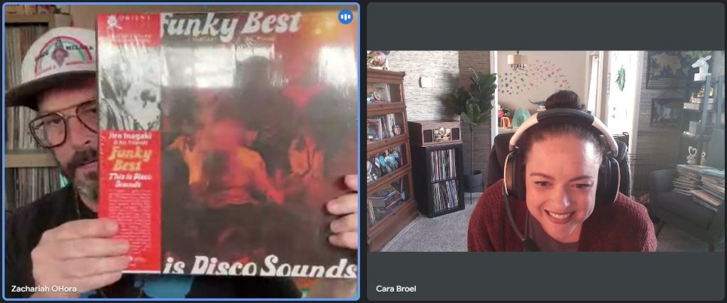 Screenshot of Google Meets meeting between Zachariah OHora and interviewer Cara Broel, a light-skinned woman with dark hair pulled into a bun. Broel looks with excitement as OHora holds up a vinyl of the album Funky Best by Jiro Inagaki.