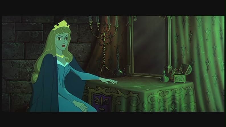 There's a stone wall with a green patterned curtain. A vanity table with a draped tablecloth, a mirror, a jewelry chest, various bottles, and a candelabra is on the right. A blonde woman with a gold crown, gold necklace, blue dress, and blue cloak stares off at a mysterious green light.