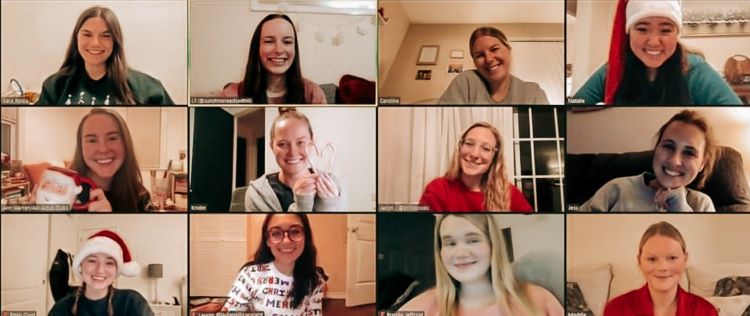 Screenshot of a virtual book club meeting hosted by Natalie. The screenshot depicts a Zoom grid of 12 women arranged in 3 rows of 4 windows, each woman smiling at the viewer. Natalie is in the top right corner wearing a Santa hat.