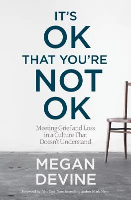 Book cover of "It's OK That You're Not OK" by Megan Devine, featuring minimalist design with large bold typography and an empty chair on a grey floor, addressing grief and emotional healing in a misunderstood culture.