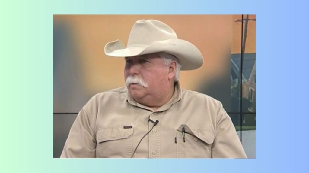 A screenshot of the author Roger Browning during an interview with a local television reporter in Wichita. He is wearing a tan work shirt and a tan cowboy hat.