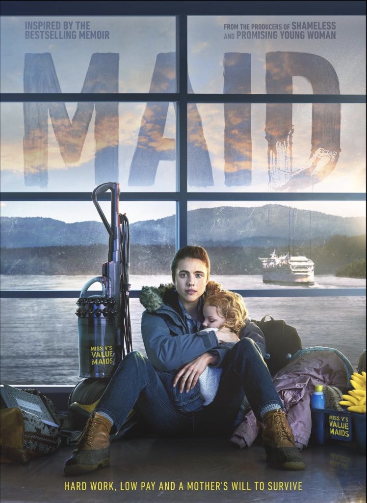 Maid 2021 Miniseries poster from Netflix. Pictured in the center is the actress Margaret Qualley. She has medium brown hair slicked back in a ponytail and fair skin. She is holding her young sleeping daughter, with curlier blonde hair, while sitting on the floor with her feet displaying work boots. On her left is a large vacuum. On her right are bright yellow cleaning gloves and cleaning sprays. Around are other bags and personal items. The scene has muted colors, and the background is water with a large mountainous region.