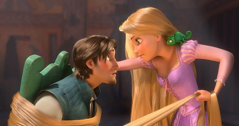 A still from Tangled. A man wearing a blue vest and white shirt is tied to a green chair with blonde hair. A young blonde woman in a purple gown leans against the chair and stares at him threateningly. On her shoulder is a green chameleon.