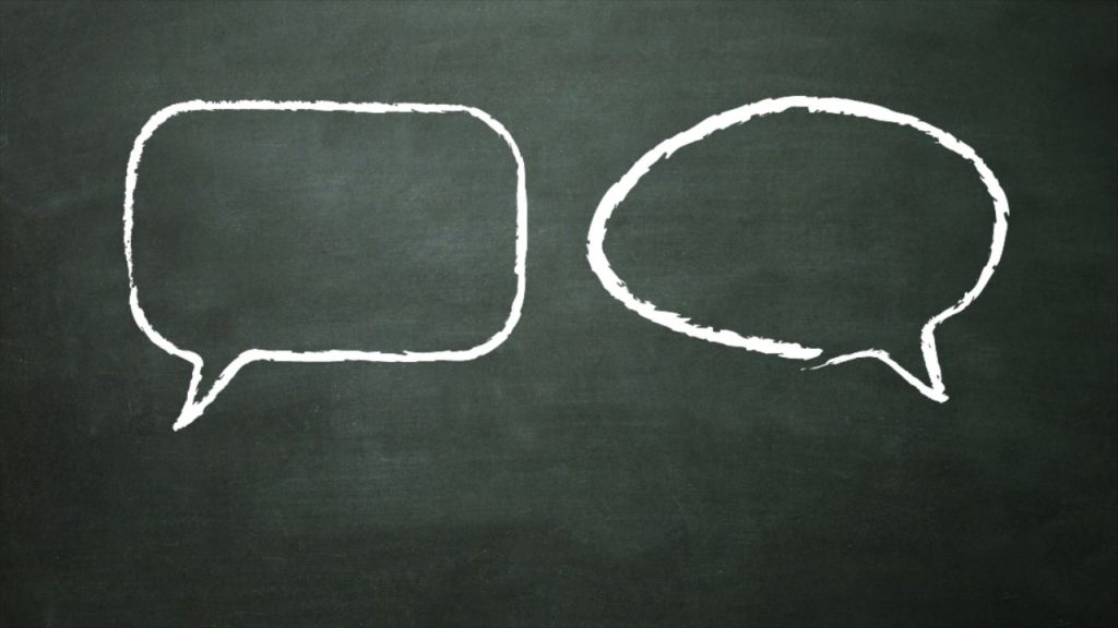 Two white speech bubbles against a chalkboard background