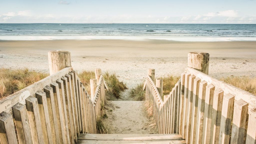 A boardwalk leading to a scenic beach and an ocean.