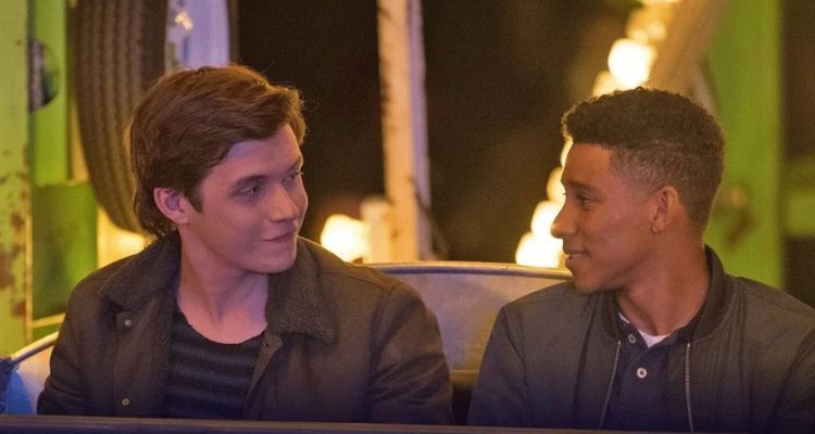 Image still from Love, Simon depicting two teenage boys smiling at each other while on a ferris wheel.