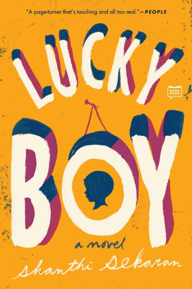The cover of Lucky Boy features a bright yellow background with the title "Lucky Boy" in large, bold, uppercase letters. Within the letter "O" of "Boy," there's a rectangular frame containing a photograph of a young boy, suggesting a central focus on his story. The author's name, "Shanthi Sekaran," appears below the title in smaller text.