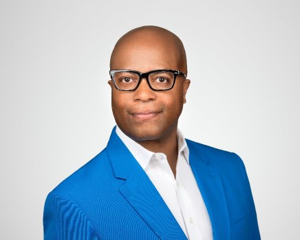 Retired Police Chief Medaria "Rondo" Arradondo, a black man in a white shirt and royal blue suit jacket smiling at the camera.