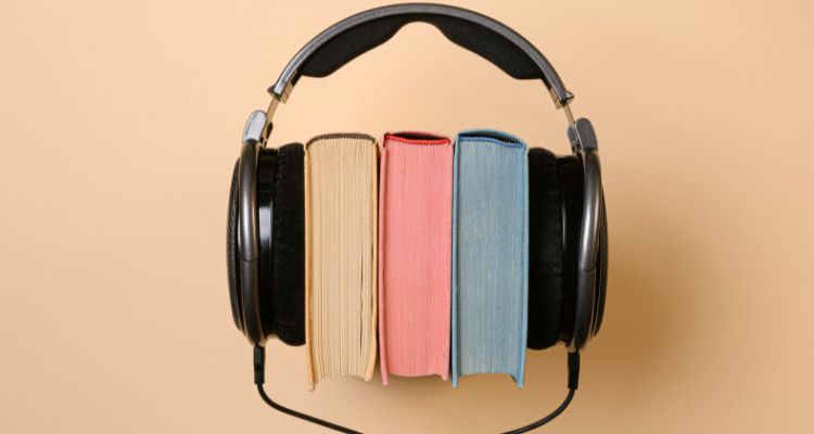 Stack of three books listening to headphones.