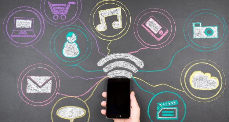 A smartphone surrounded by chalk drawn social media apps of different colors.