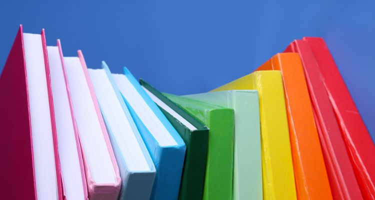 Rainbow books (purple, blue, green, yellow, orange, pink, red) on a blue background.