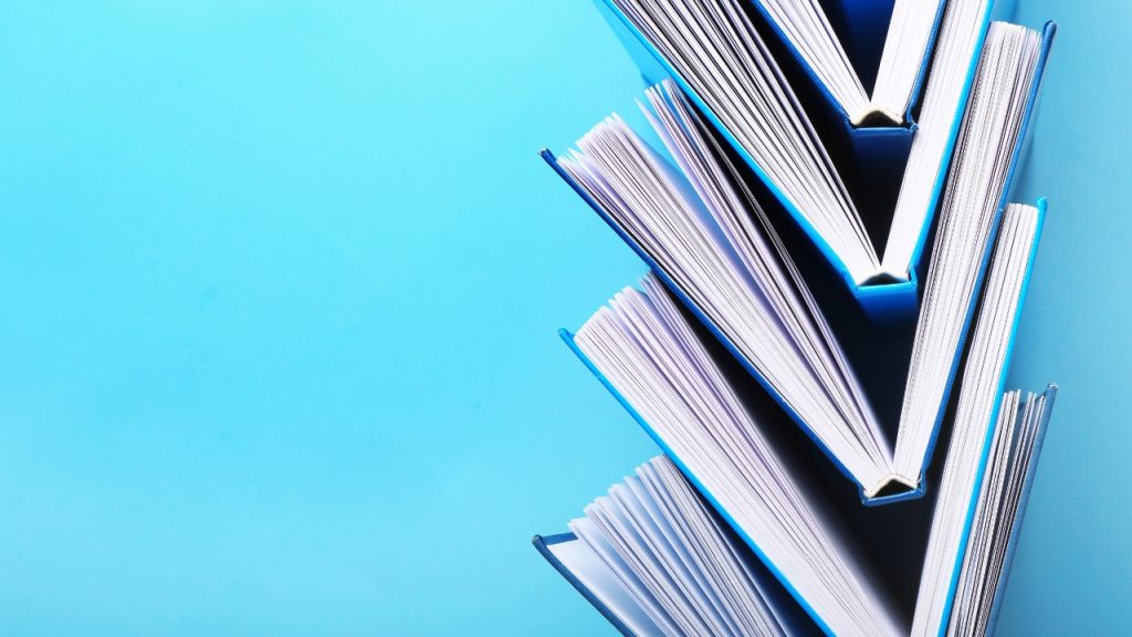 A blue background with five blue books stacked inside of one another.