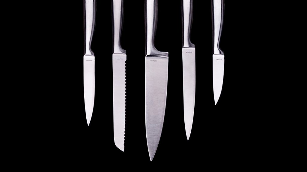 A black background with five silver knives.