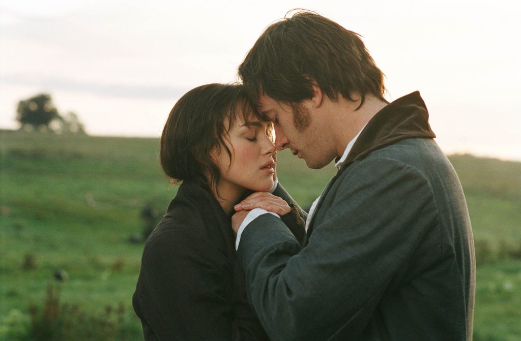 Image from Pride and Prejudice (2005) featuring Elizabeth Bennet and Mr. Darcy in a forehead-to-forhead position with their eyes closed. They are in a grassy, outdoor setting.