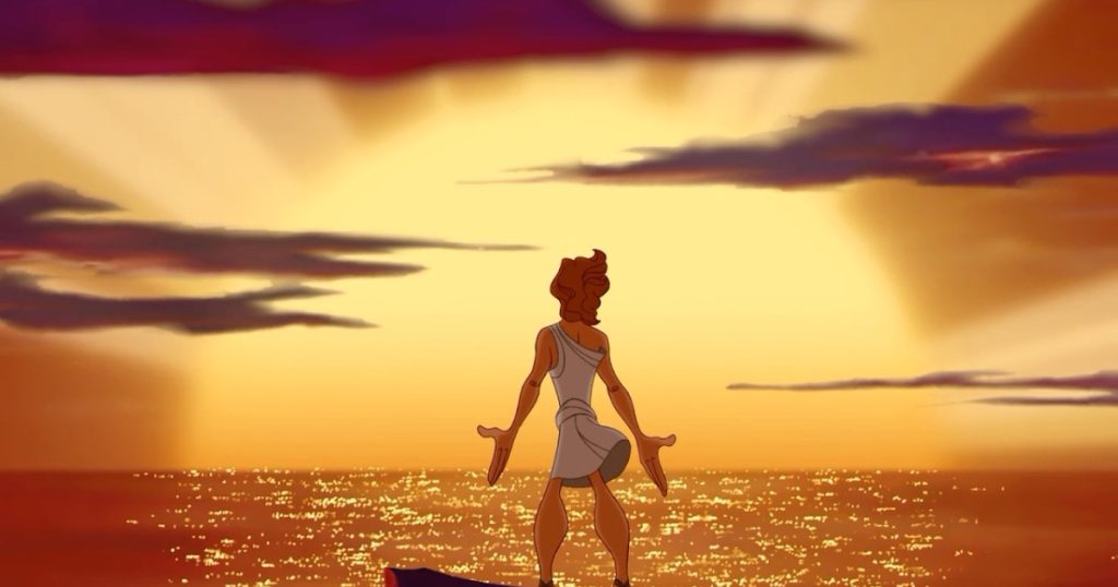 A still from the 1997 animated movie Hercules. A young man in a traditional white Greek chiton stands on a cliffside over the ocean with his arms open at his sides. He looks off into a large golden sunset with shooting rays and purple clouds that bathes the water in glittering orange light.