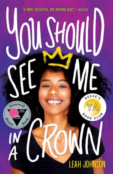 Book cover of "You Should See Me in a Crown" by Leah Johnson. Features a smiling young person with a yellow crown illustration. Includes Stonewall Honor Book and Reese's YA Book Club badges. Vibrant purple background.