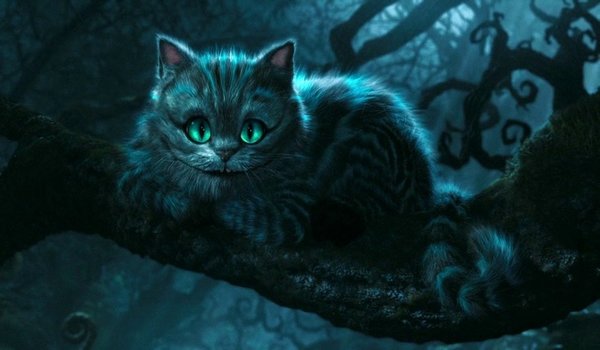 Movie still from Walt Disney's live-action Alice in Wonderland. Image depicting a grey and black tabby cat with emerald green eyes and a wide toothy smile perched on a large treen branch in the dark forest.
