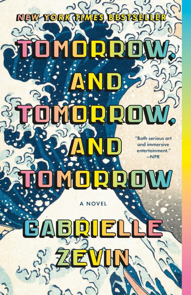Tomorrow and Tomorrow and Tomorrow by Gabrielle Zevin book cover. Version of the painting "The Great Wave off Kanagawa" showing a giant wave in the background with rainbow text.