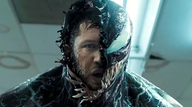 Venom (2018) still, depicting Eddie transforming into Venom with half of his face as Venom and the other as himself with thin black lines running up the side of his face.