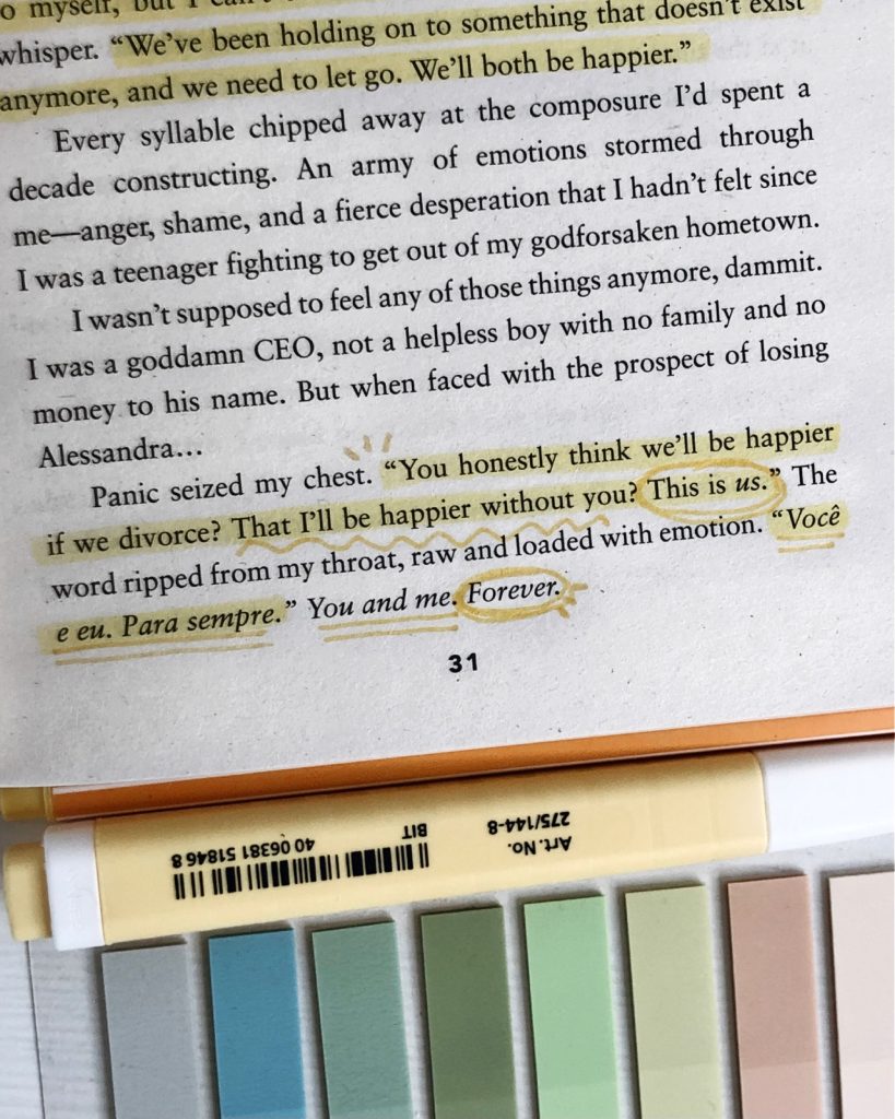 A close up of a page from a novel with the bottom paragraph annotated in yellow marker. Carla switches between highlighting, squiggly underlines, straight underlines, circles, and little sun beams to annotate the lines. Underneath the book lies a yellow marker and colorful sticky notes for books.