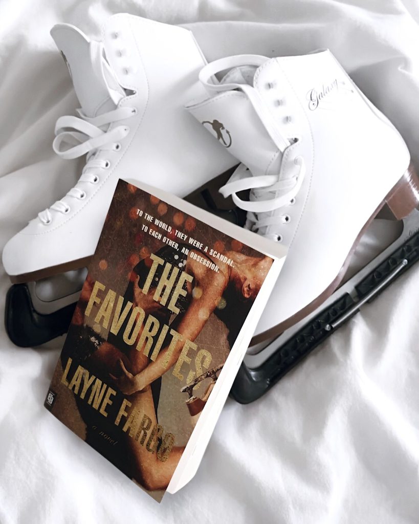 The Favorites by Layne Fargo, published by Berkeley, sit on top of pristine white ice skates laying on a white sheeted bed. The cover shows two ice skating partners amidst a dramatic lift.