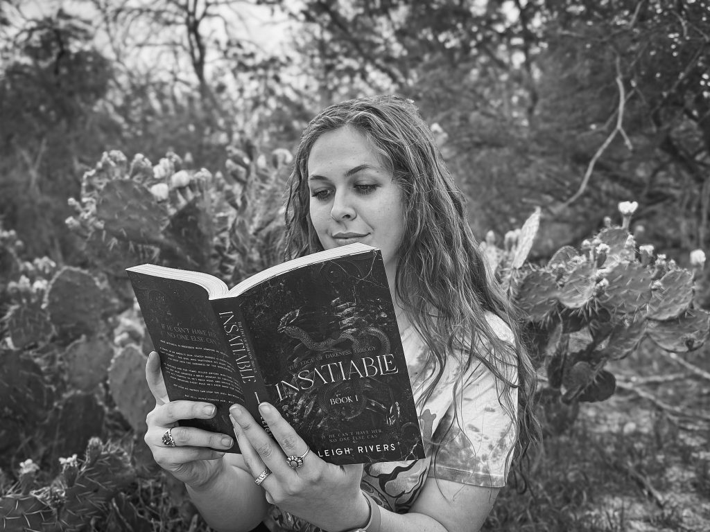 Caitlyn of @bound.in.darkness reads Insatiable by Leigh Rivers ourside