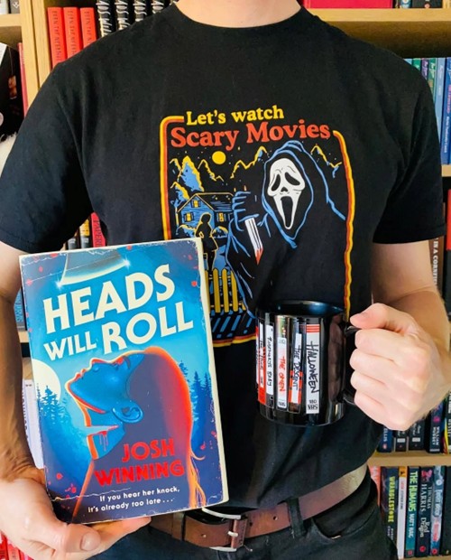 Horror author Josh Winning hosting a giveaway with prizes of his book 'Heads Will Roll', a Ghostface (character from Scream) top and a mug with classic horror movie VHSes design