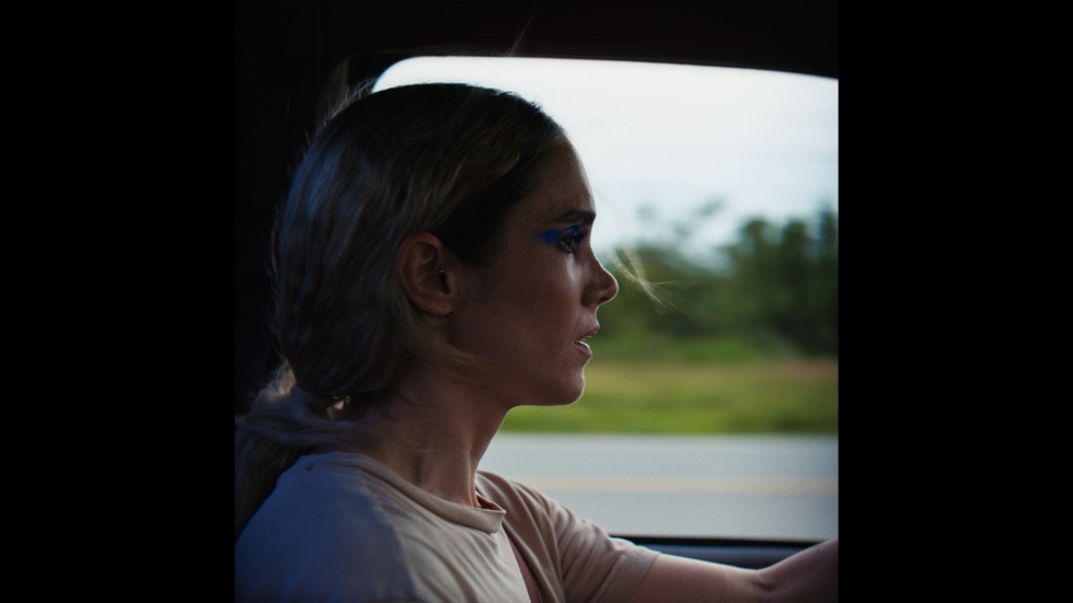 Charliebird film still. Side profile of actress Samantha Smart as Al is visible from the shoulders up as she drives a car.