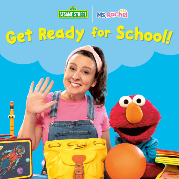 Smiling woman Ms. Rachel in pink shirt and overalls waves beside a red furry puppet. School-themed items like a yellow backpack and lunchbox are in front.