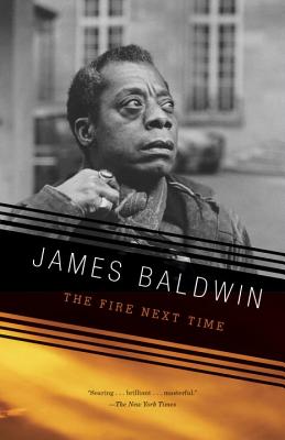 The Fire Next Time by James Baldwin book cover of a black and white image of James Baldwin outside of a building looking up and to the side.