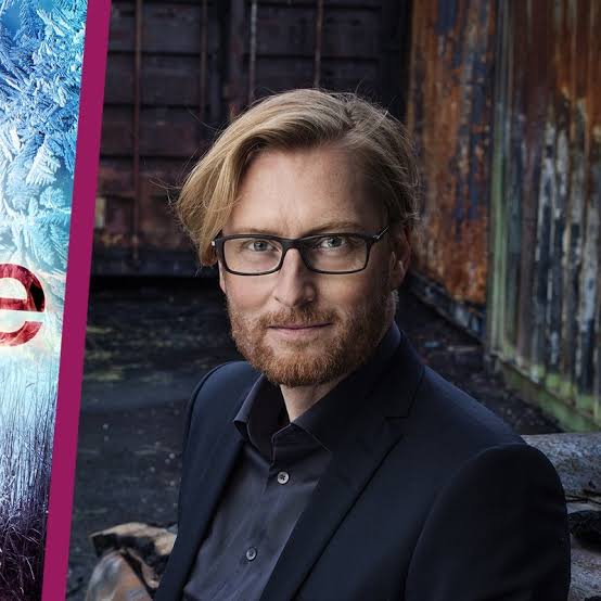 Crime fiction author Anders de la Motte wearing a suit with an alleyway in the background.