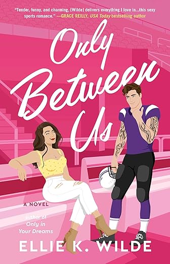 Only Between Us by Ellie K. Wilde book cover, depicting an illustration of a woman sitting on a bench and smiling smugly at a tattooed man in football gear. The background is mainly hot pink and depicts the seating area of a football stadium. The title is across the top half of the cover in white cursive letters, with the author's name at the bottom of the cover.