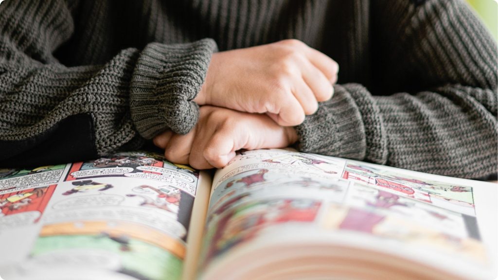 A close-up image of a middle school aged child reading a graphic novel.