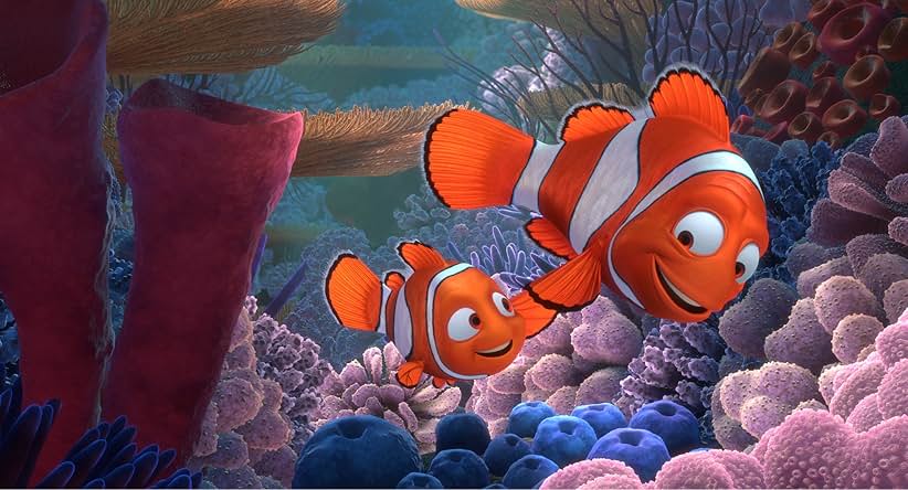 Finding Nemo movie still. Depicting two clown fish, a father and a son holding fins and smiling at each other.