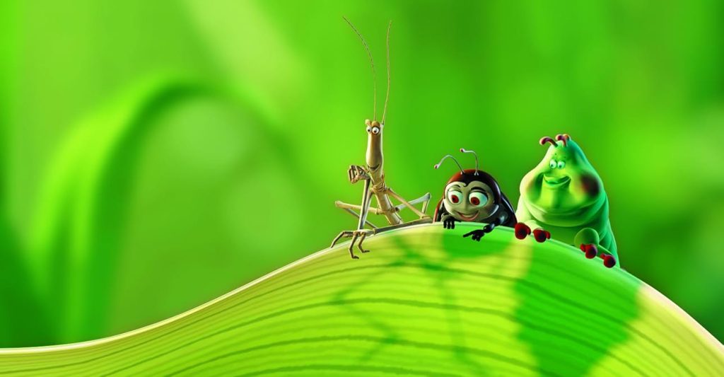 A Bug's Life movie still depicting a stick bug, lady bug, and a caterpillar peaking over a blade of grass.