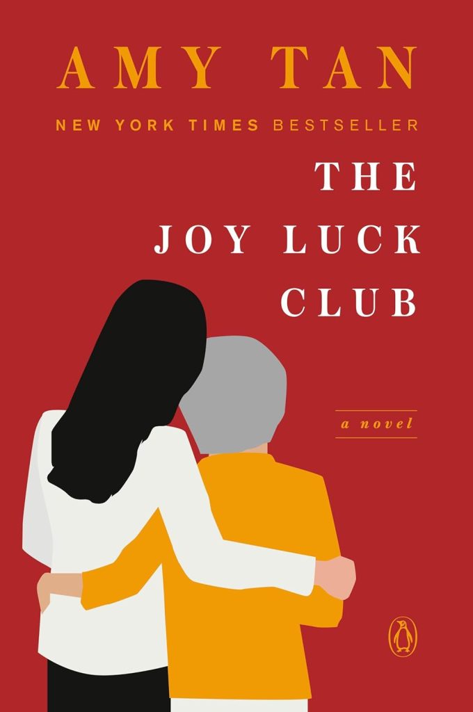 The Joy Luck Club by Amy Tan book cover. Depicts a graphic drawing of the back of a young woman with her arm around an older woman.